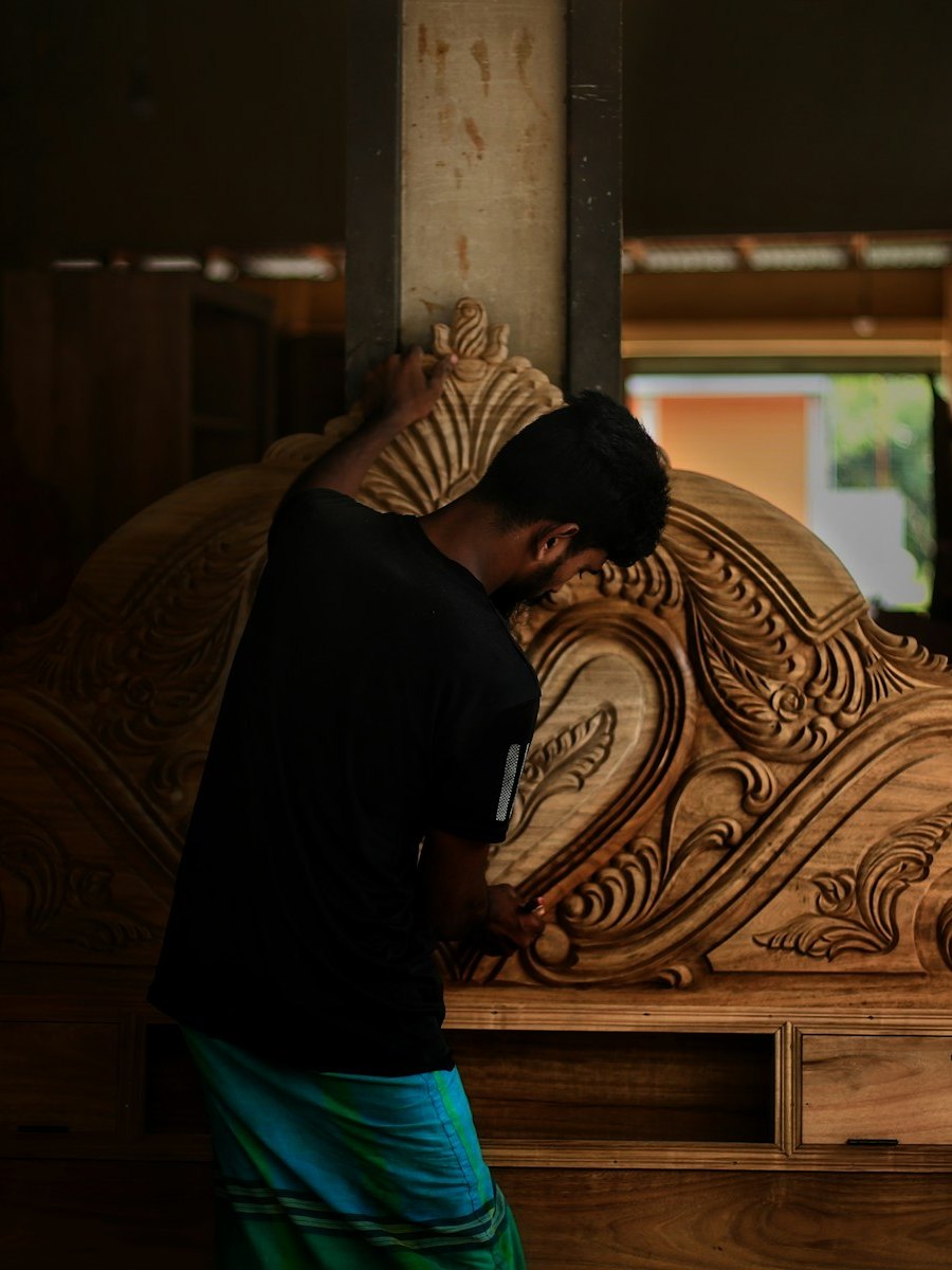 A carver shaping a large ornamental panel