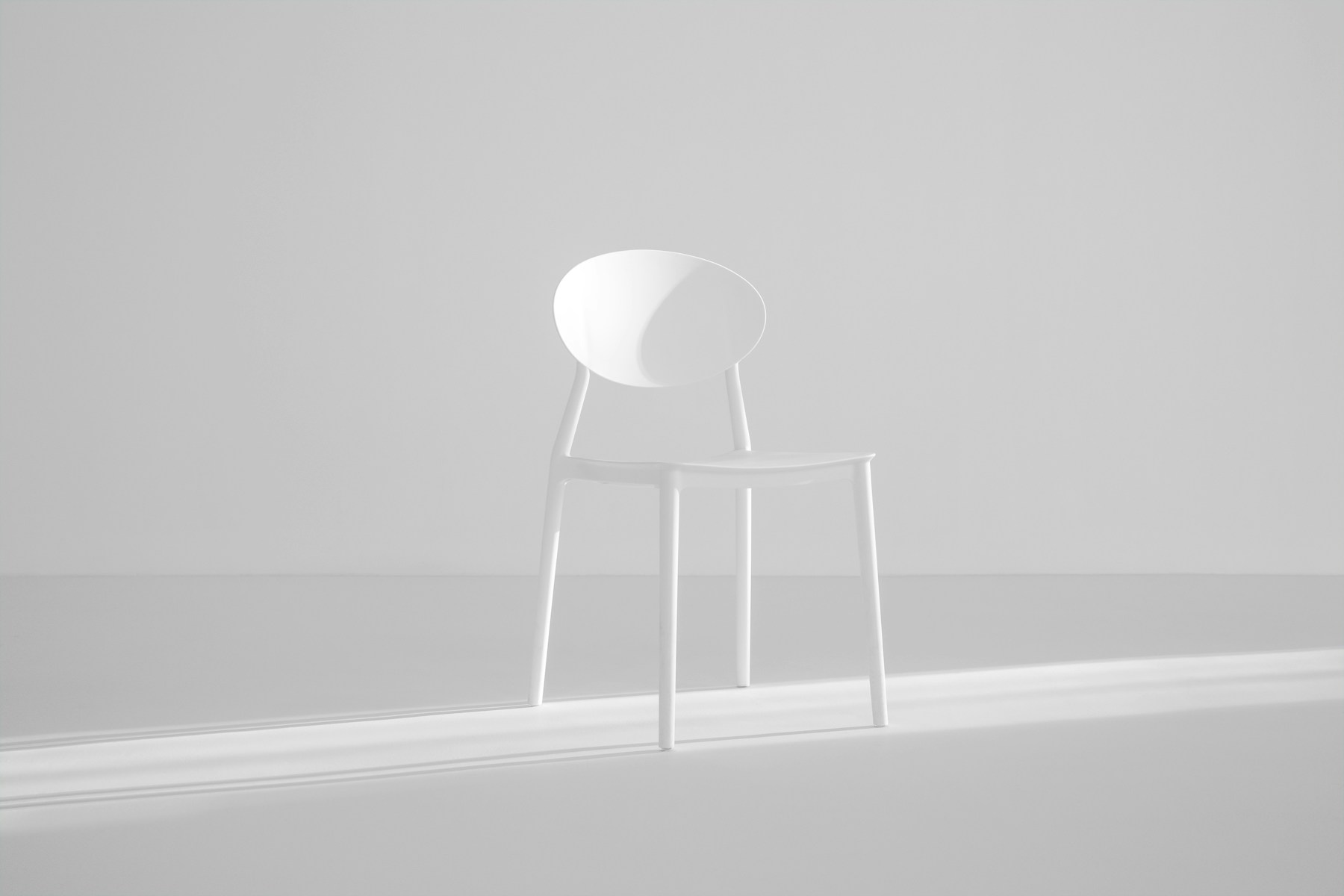 A slender studio chair against a plain wall